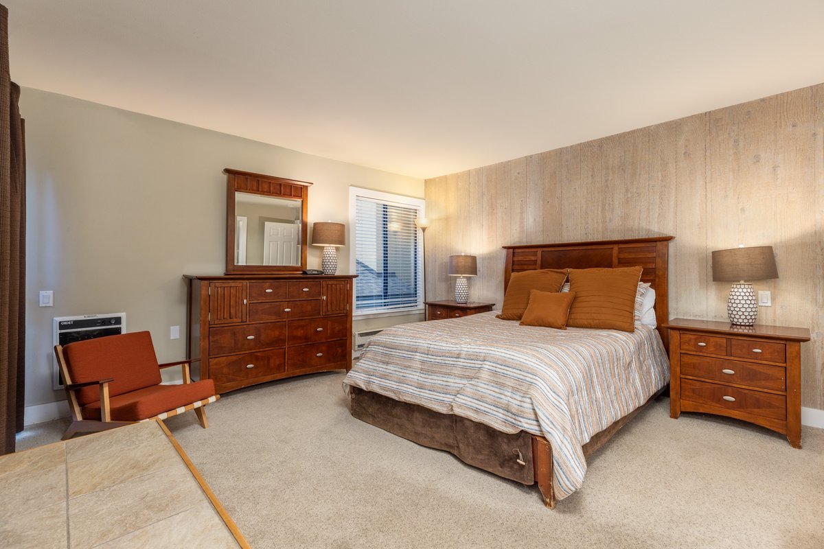 Guest bedroom with bed, dresser, and seating