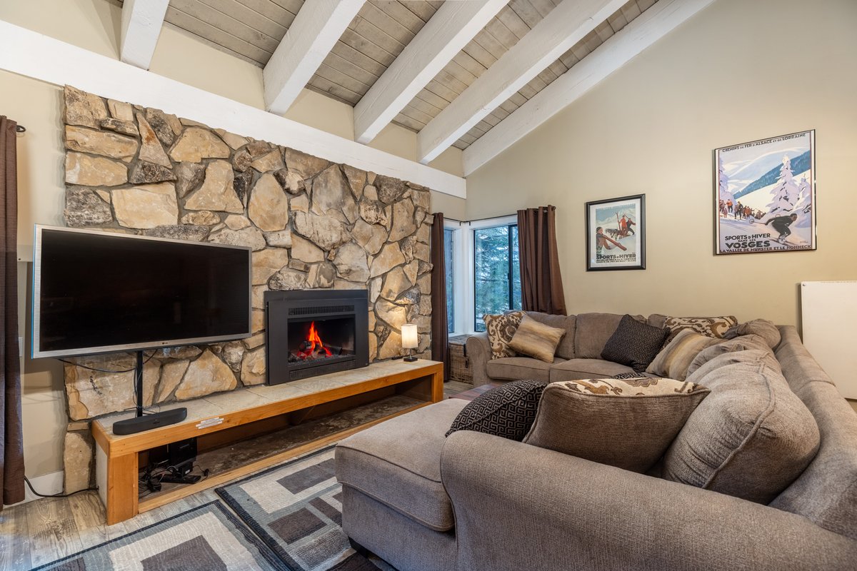 Living room with stone gas fireplace, sectional, and TV